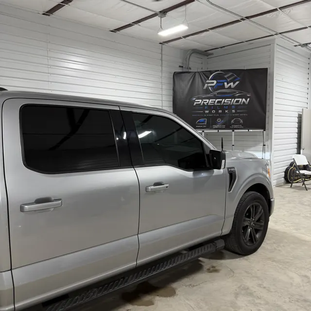 Silver pickup with dark window tint, side view